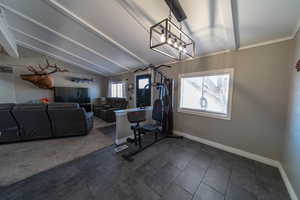 Dining area featuring dark tile flooring and vaulted ceiling