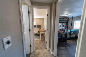 Corridor featuring hardwood / wood-style floors and a textured ceiling