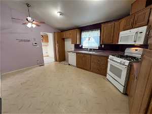 Kitchen featuring ceiling fan, light tile floors, lofted ceiling, white appliances, and sink