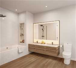 Full bathroom featuring oversized vanity, toilet, hardwood / wood-style floors, double sink, and tiled shower / bath combo