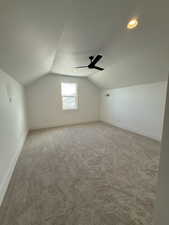 Bonus room with ceiling fan, vaulted ceiling, carpet flooring, and baseboards