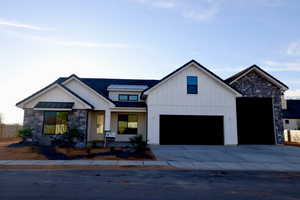 Modern inspired farmhouse featuring board and batten siding, a standing seam roof, metal roof, and concrete driveway