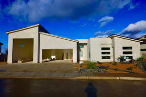 Exterior space with concrete driveway, an attached garage, and stucco siding