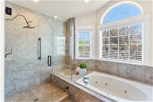 Bathroom featuring lofted ceiling and separate shower and tub