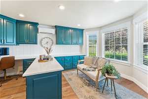 Kitchen featuring light hardwood / wood-style flooring, blue cabinets, a kitchen island, and built in desk