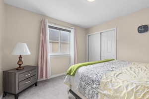 Bedroom featuring light carpet and a closet