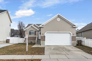 View of front of property with a garage and a front lawn