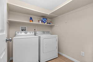 Laundry room with washer and dryer, light tile flooring, and washer hookup