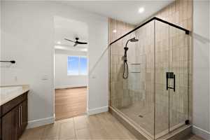 Bathroom featuring tile floors, ceiling fan, vanity, and walk in shower