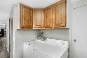 Laundry room with washer hookup, washer and clothes dryer, cabinets, and hardwood / wood-style floors