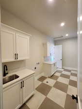 Washroom featuring cabinets, sink, washer hookup, and hookup for an electric dryer