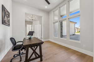 Office space featuring baseboards, recessed lighting, light wood finished floors, and a chandelier