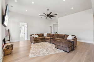 Living room featuring baseboards, recessed lighting, ceiling fan, and light wood-style flooring