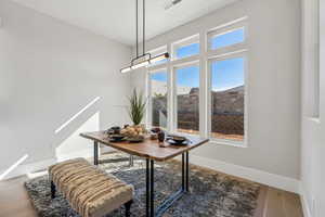 Dining space featuring baseboards, visible vents, and wood finished floors