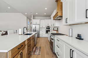 Kitchen with stainless steel appliances, recessed lighting, a sink, and custom range hood