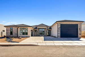Prairie-style home with stone siding, a garage, stucco siding, a tiled roof, and driveway