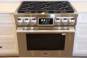 Interior details featuring white cabinetry and gas stove