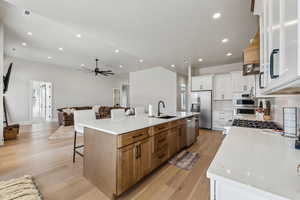 Kitchen with a sink, stainless steel appliances, open floor plan, a large island, and visible vents