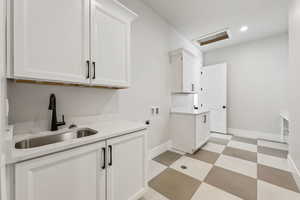 Clothes washing area featuring washer hookup, attic access, electric dryer hookup, a sink, and light floors