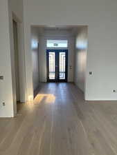 Entrance foyer with french doors and hardwood / wood-style floors