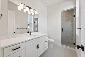 Bathroom with vanity, baseboards, toilet, and a shower stall