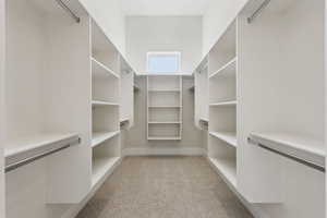 Spacious closet featuring light carpet