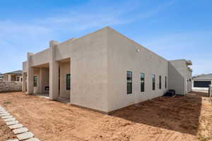 Rear view of property with stucco siding and cooling unit