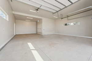 Garage featuring baseboards and a garage door opener