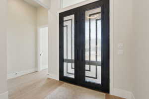 Entryway with french doors, baseboards, and wood finished floors