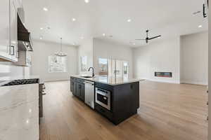 Kitchen with recessed lighting, a sink, appliances with stainless steel finishes, and ceiling fan with notable chandelier