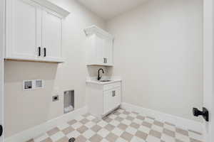 Laundry room with hookup for a washing machine, light floors, electric dryer hookup, a sink, and cabinet space