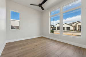 Spare room with baseboards, ceiling fan, hardwood / wood-style flooring, and visible vents