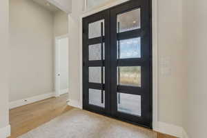 Foyer featuring baseboards, french doors, and wood finished floors