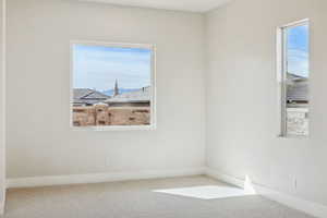 Carpeted empty room featuring baseboards