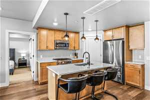 Kitchen with decorative light fixtures, stainless steel appliances, backsplash, sink, and carpet flooring