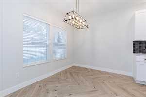 Unfurnished room featuring an inviting chandelier and light parquet flooring