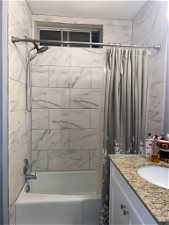 Bathroom featuring shower / bathtub combination with curtain and vanity