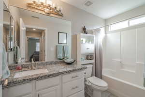 Full bathroom featuring toilet, tile floors, shower / tub combo, and oversized vanity