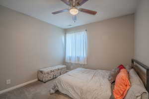 Bedroom with ceiling fan and dark carpet