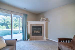 Living room with a fireplace and light colored carpet