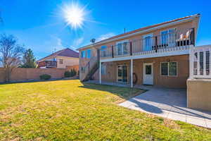 Back of property with a yard and a patio area