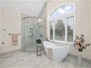 Master bathroom with shower with separate bathtub and tile flooring
