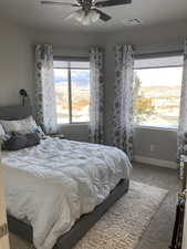 Bedroom with ceiling fan and light colored carpet