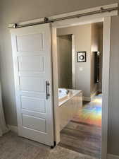 Bathroom with wood-type flooring and tiled bath