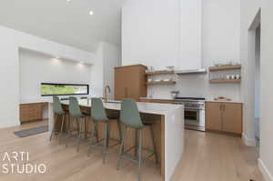 Kitchen featuring a center island, light hardwood / wood-style floors, a breakfast bar, and high end stove