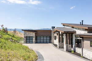 View of front facade with a garage and a mountain view