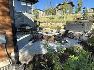 Rear patio with terraced yard, fire pit, hot tub, outdoor kitchen and dining