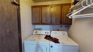 Laundry area featuring cabinets and washer and dryer