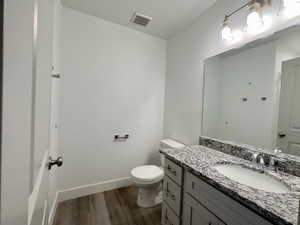 Bathroom featuring toilet, LVP flooring, and vanity and shower