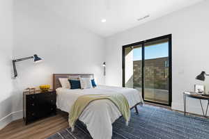 Bedroom featuring dark hardwood / wood-style floors, ceiling fan, and access to outside